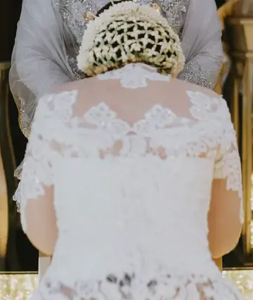 The bride's lace gown and jasmine hair arrangement, seen from behind